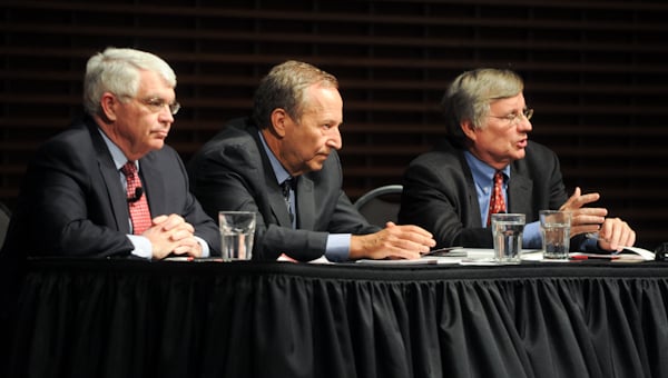 John B. Taylor sits on a panel with two other speakers behind a table