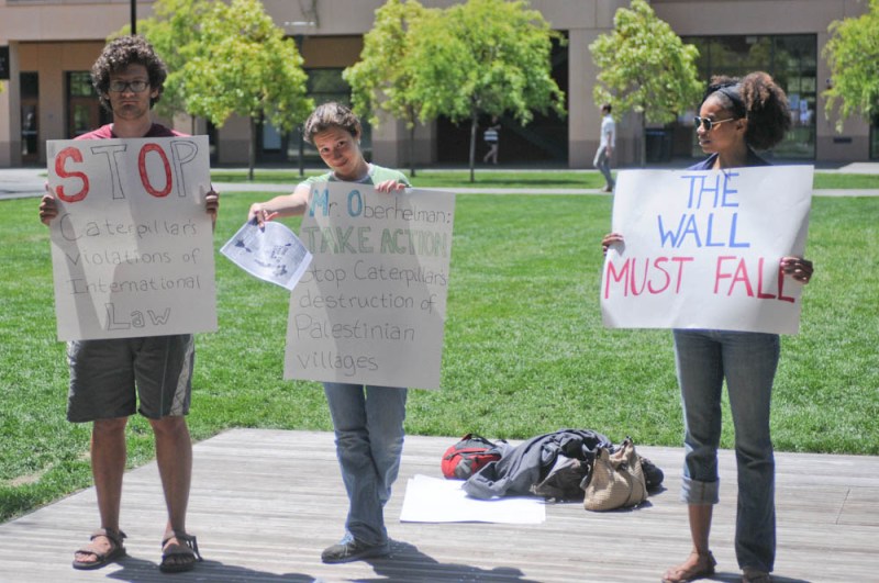 Three students protested outside a talk by Dougla Oberhelman, Caterpillar CEO, Thursday. (MEHMET INONU/The Stanford Daily)