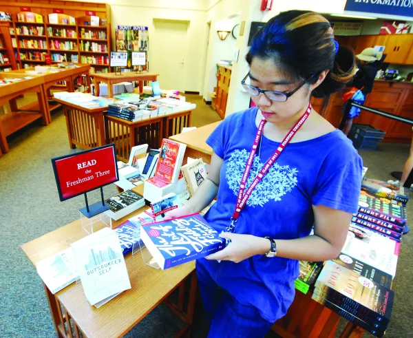 An incoming freshman peruses a copy of "The Art of Fielding" by Chad Harbach in the Stanford Bookstore. (MADDY SIDES/The Stanford Daily)