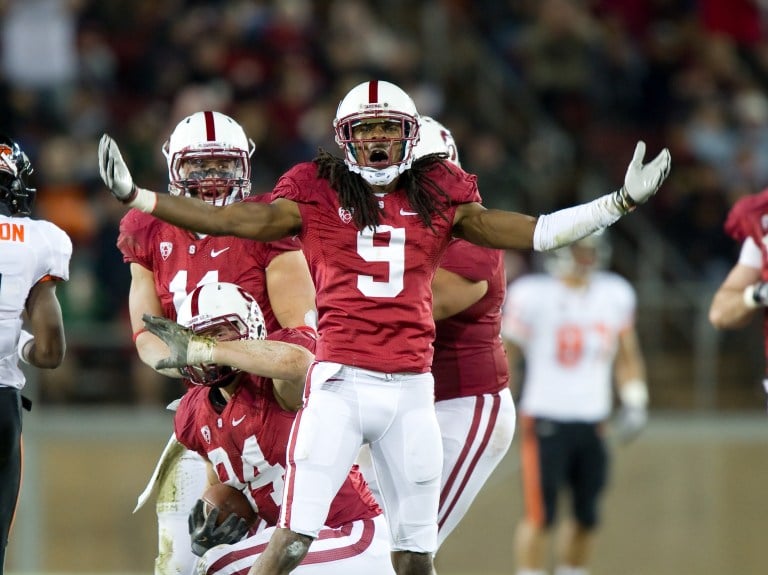 A football player holds his hands up in jubilation.