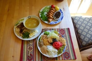 A collection of three Burmese dishes: samosas, ohn no khao swè (a coconut chicken noodle soup), and tea salad by Chef Ma. (Courtesy of Justin Lee)