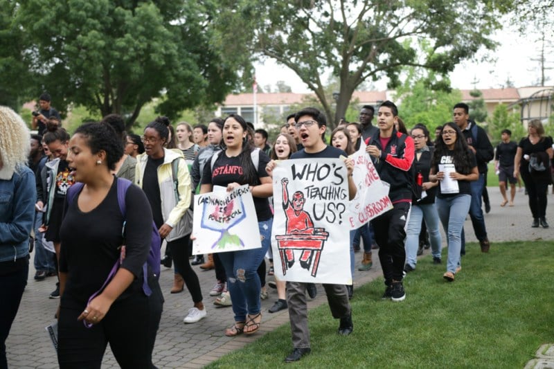 Student activists hold signs and march in a rally.