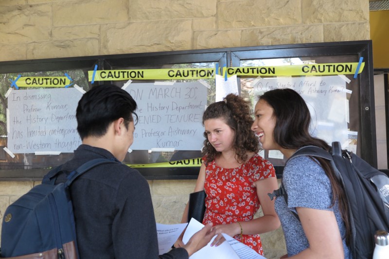 Truman Chen '17 hands out fliers to passersby at the demonstration (NINA ZUBRILLINA/The Stanford Daily).