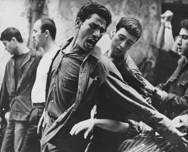 Brahim Haggiag (center, with arm outstretched) as  revolutionary leader Ali La Pointe in a scene from Gillo Pontecorvo's THE BATTLE OF ALGIERS (1965). Photo courtesy of British Film Institute/Rialto Pictures.