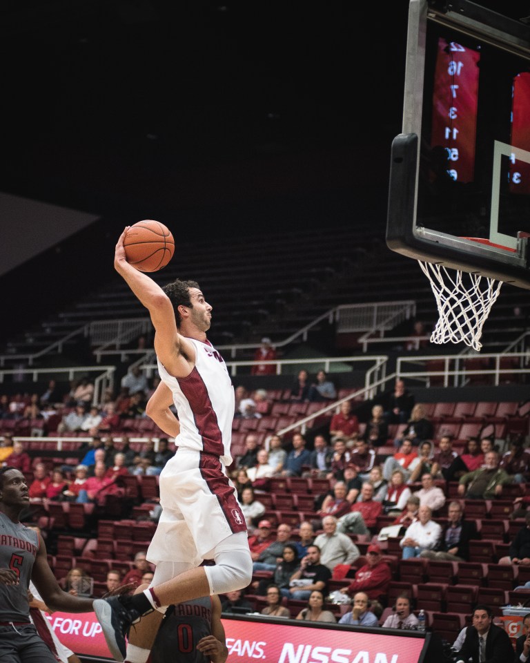 Josh Sharma cocks back the ball before an emphatic finish at the rim on Tuesday night in a home opener victory for Stanford. Sharma was 7-10 shooting with 15 points and five rebounds. (RYAN JAE/The Stanford Daily)