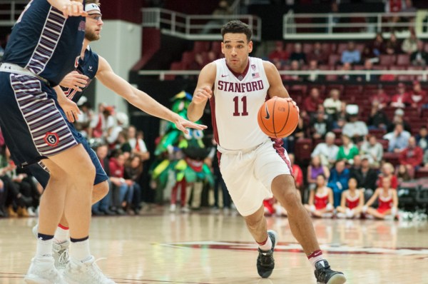 Junior guard/forward, Dorian Pickens, dribbles the ball down the court past oncoming defenders. Pickens is currently one of the team's leading scorers, and has been strong from the three-point line. (RAHIM ULLAH/The Stanford Daily)
