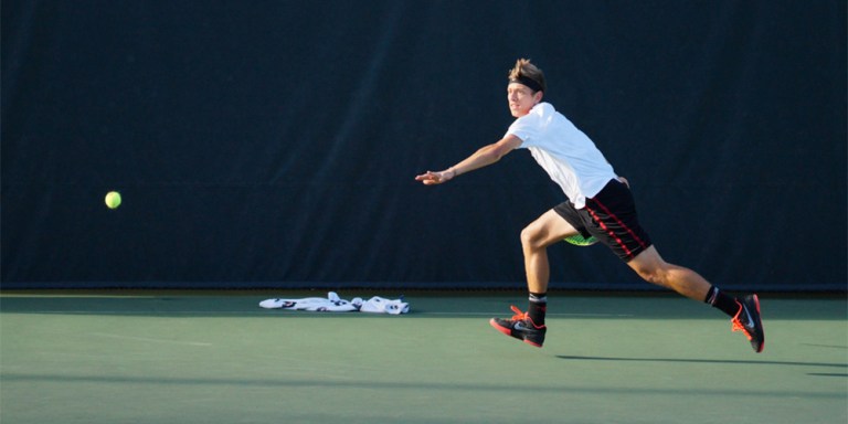 Junior David Wilczyinski prepares to volley the ball back over the net.  Wilczyinski has come up with two 3-0 set wins this season. (LARRY GE/The Stanford Daily)