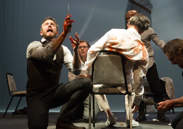 “Ambition's debt is paid!” proclaims Brutus (Danforth Comins, with knife) after the assassination of Caesar (Armando Durán, in chair), with Metellus Cimber (Ted Deasy), Cassius (Rodney Gardiner) and Caska (Stephen Michael Spencer) in the Oregon Shakespeare Festival's 2017 production of 'Julius Caesar' (Photo by Jenny Graham).