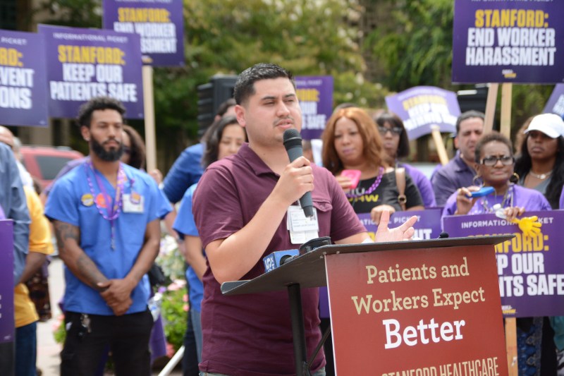 Joseph Corona, an Employee Benefit Specialist (EBS) for Stanford Health Care, shares his experiences at the picket organized by SEIU-UHW (JESSICA ZHANG/The Stanford Daily).