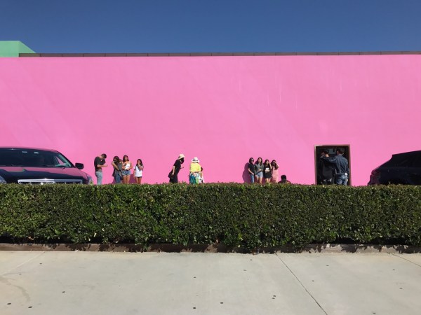 Tourists pose in front of a popular pink wall in Los Angeles. (GEORGINA GRANT/The Stanford Daily).