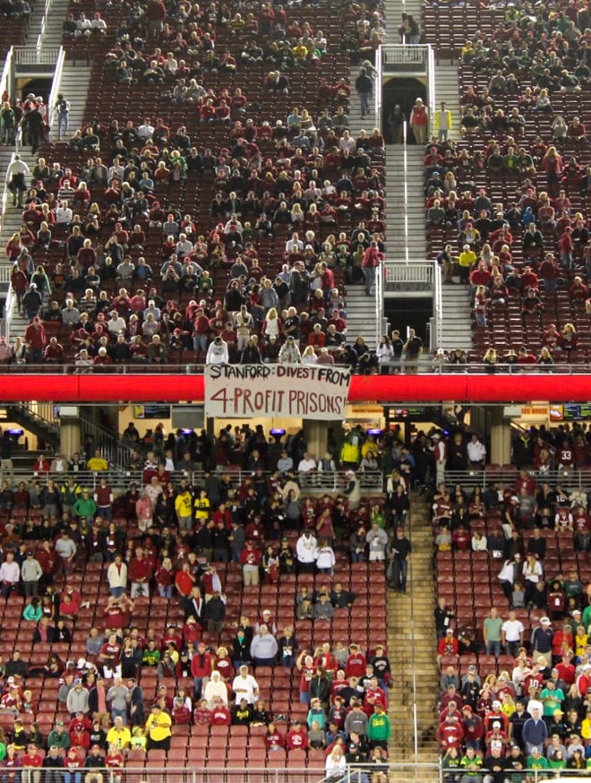 Students push back on prison divestment decision with banner at homecoming game