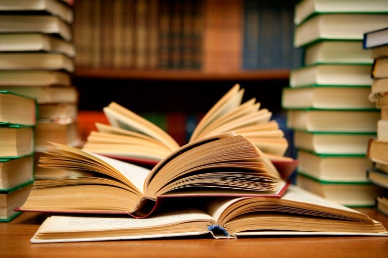 Books laid open on a desk inside a library