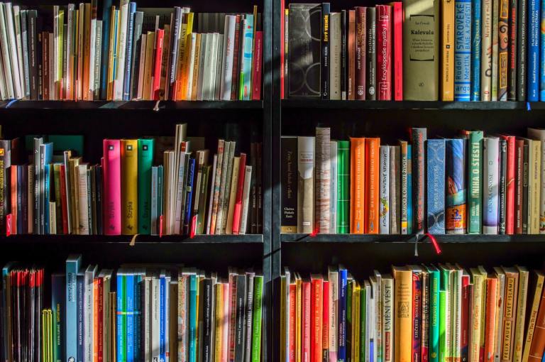 A bookshelf of colorful books in a library.