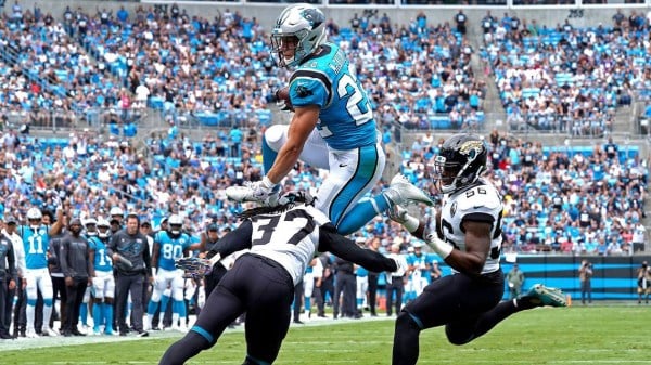 Scoring his first of three touchdowns on the day, Carolina Panthers running back Christian McCaffrey leaps over two Jaguars defenders. A 2017 first-round pick out of Stanford, McCaffrey dominated the game, racking up a franchise-record 237 all-purpose yards. (JEFF SINER/Charlotte Observer)