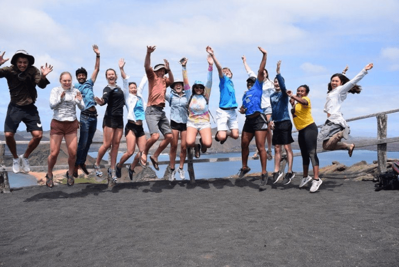 A group of 2019 SoCo participants jump for joy on Bartolomé Island. Courtesy of Jose Urteaga.