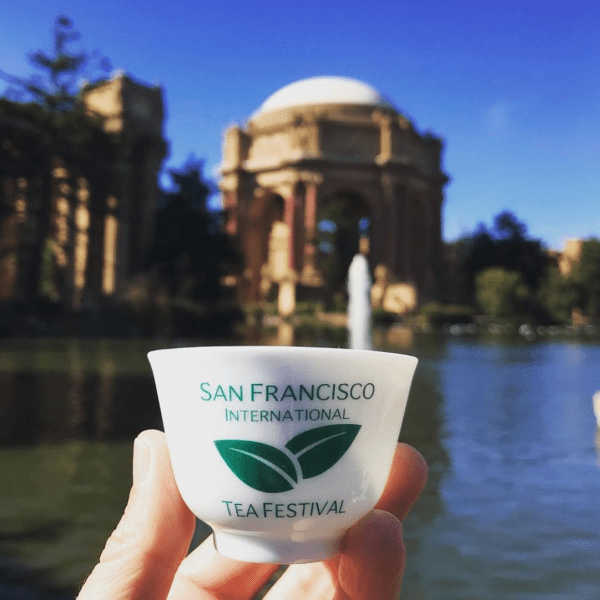 A festival attendee holds a complimentary SF International Tea Festival cup in front of the Palace of Fine Arts.  (Photo courtesy of SF International Tea Festival)