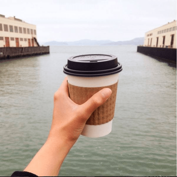 A warm cup of coffee held against a cool backdrop (Photo: SF Coffee Festival).