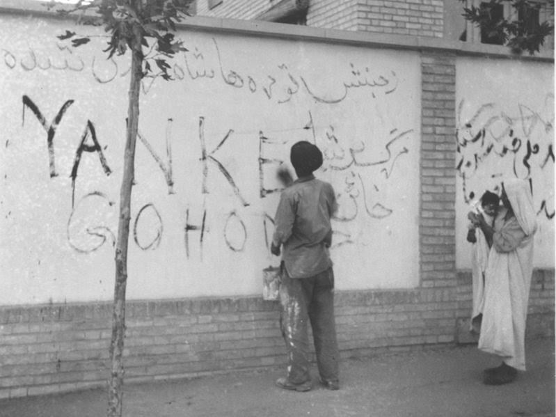 A man washes "Yankee Go Home" from a wall during a citywide cleanup following the 1953 coup d'état in the Iranian capital of Tehran. (Courtesy of AP)