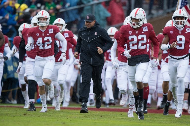 Stanford head football coach David Shaw (above, center) announced the signing of four additional recruits on National Signing Day on Wednesday. Shaw emphasized size and versatility as features of emphasis in this year's recruiting process and ended the conference by thanking the new recruits as well as Stanford's coaching and scouting staffs. (PHOTO: Grant Shorin/isiphotos.com)