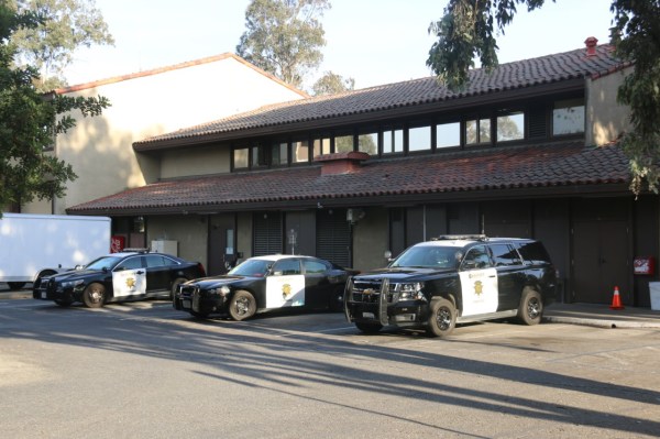 Three police cars parked at the back of the Stanford Department of Public Safety building.