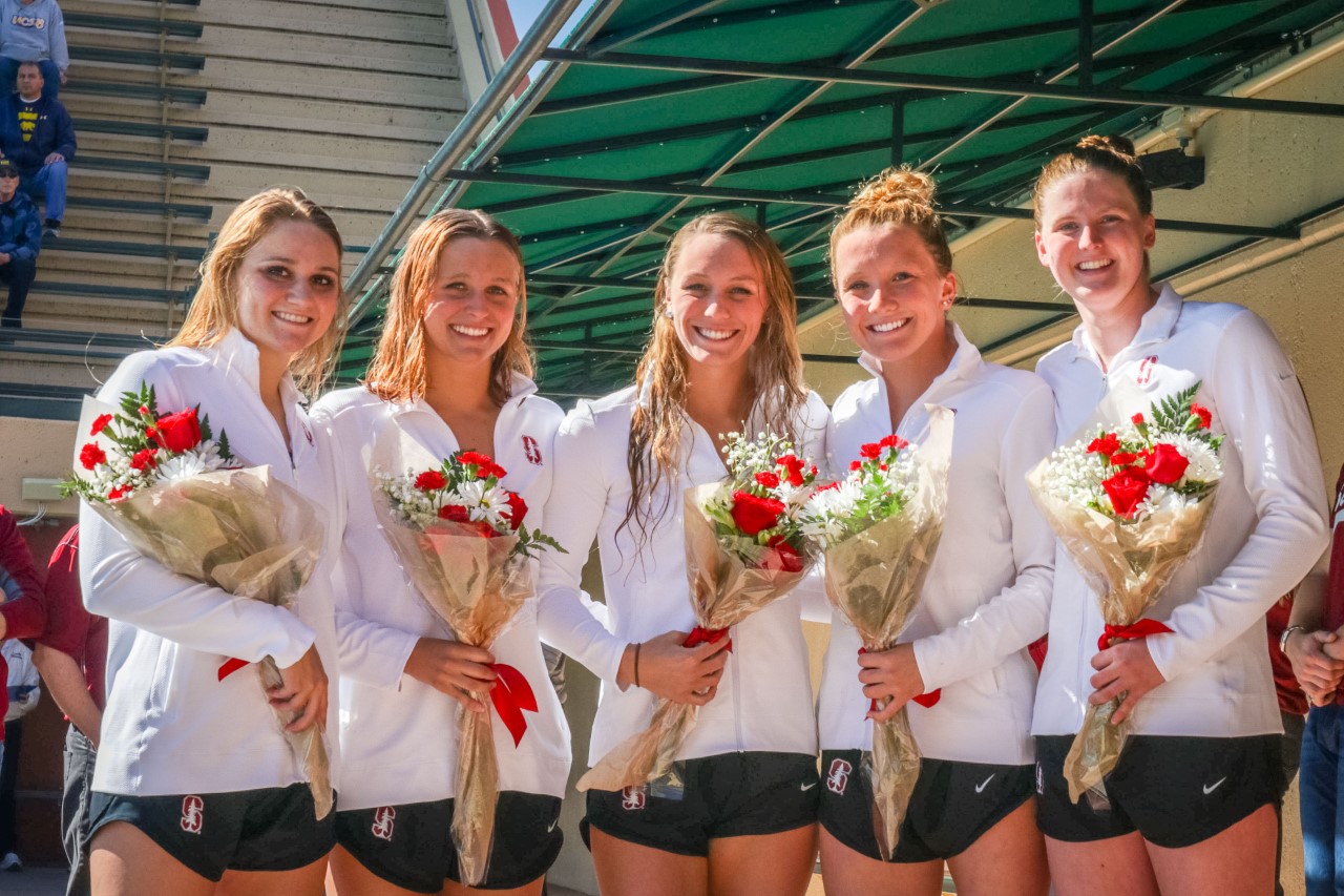 Seniors Megan Byrnes, Katie Drabot, Brooke Stenstrom, Allie Szekely and Erin Voss stand and hold flowers at their final meet on the Farm.