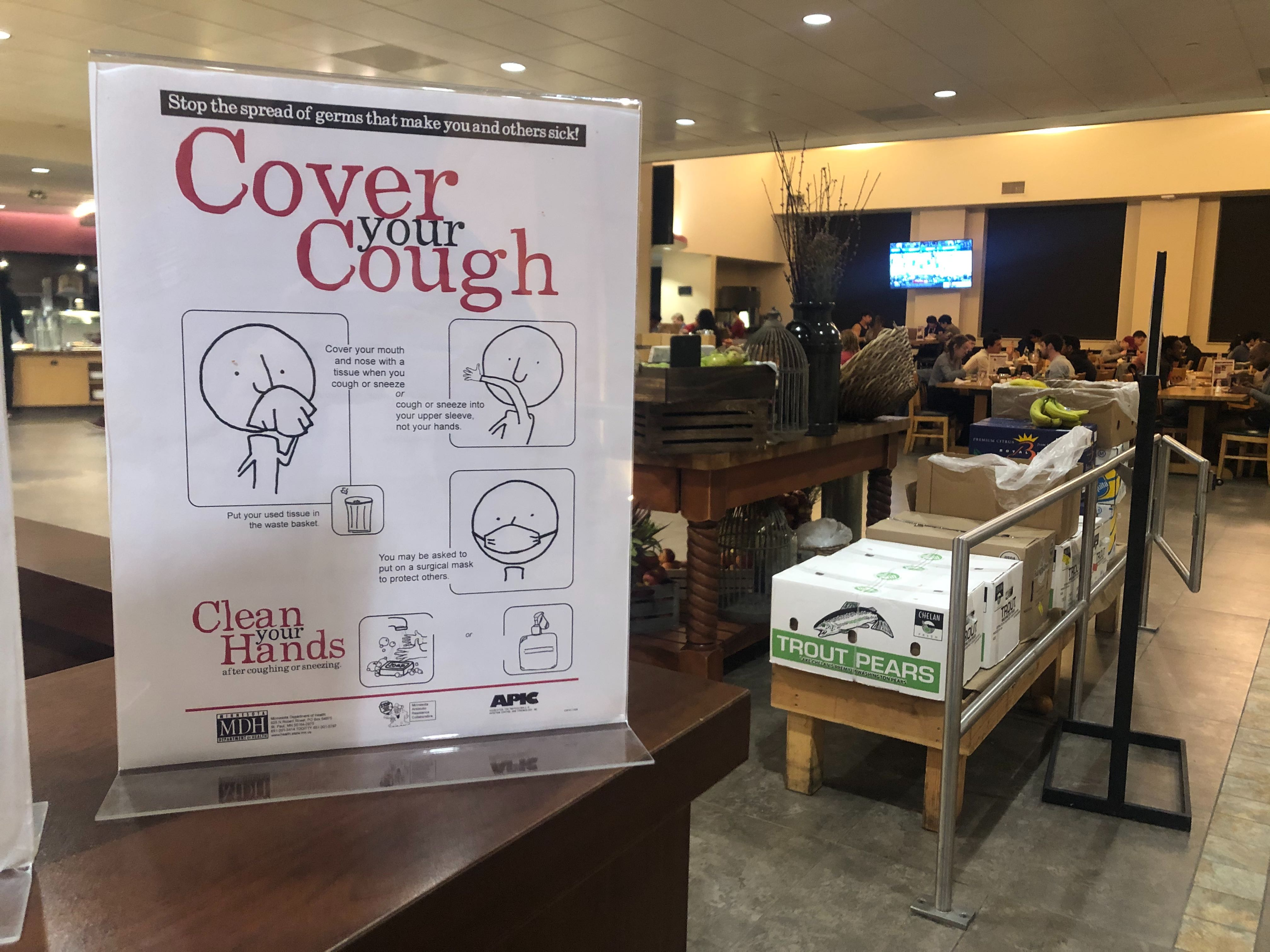 A sign in the Arillaga Family Dining Commons says, 'Cover your Cough.'