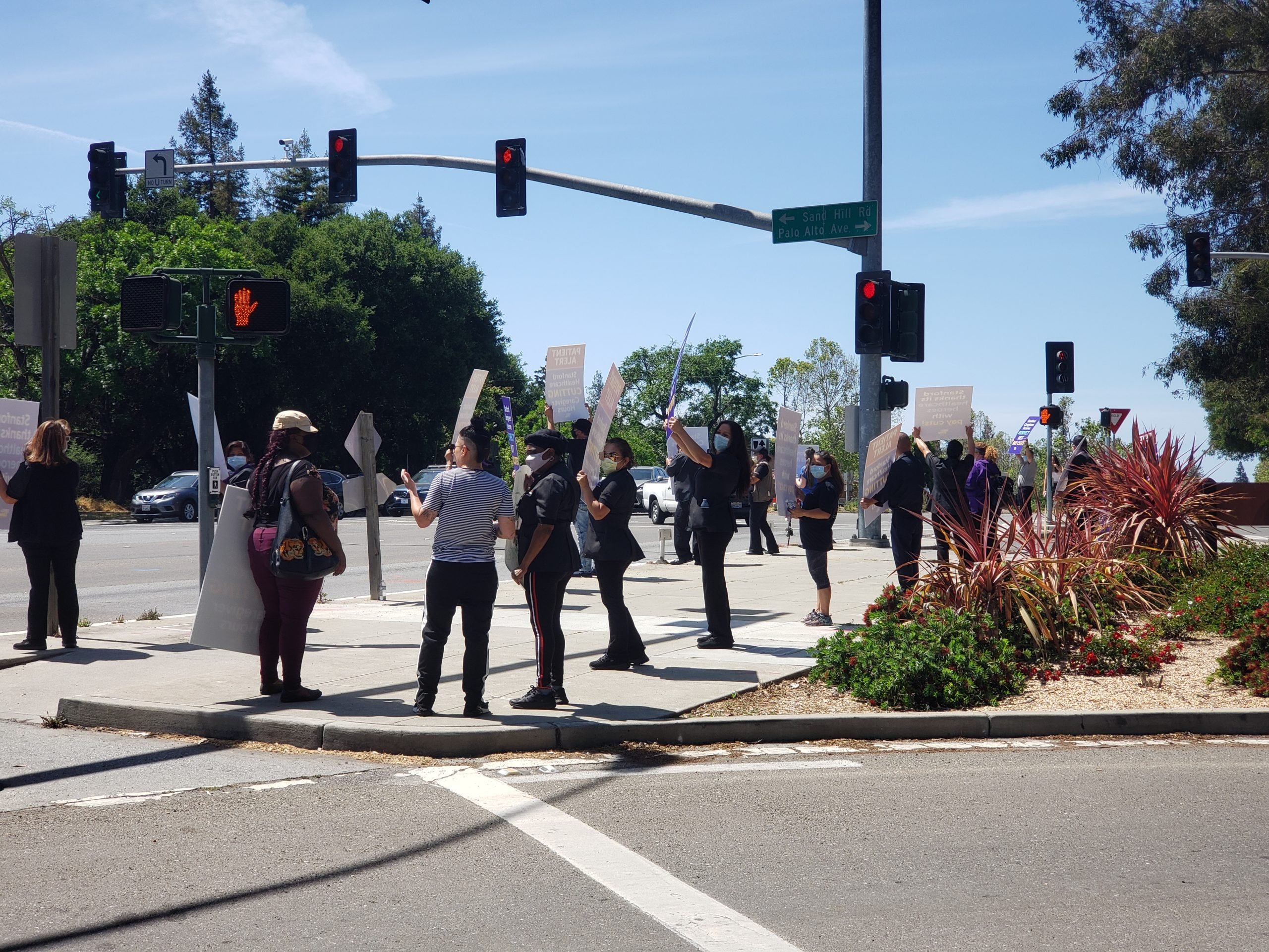 Healthcare workers demonstrate while maintaining social distancing at the corner of Sand Hill Road and El Camino Real.
