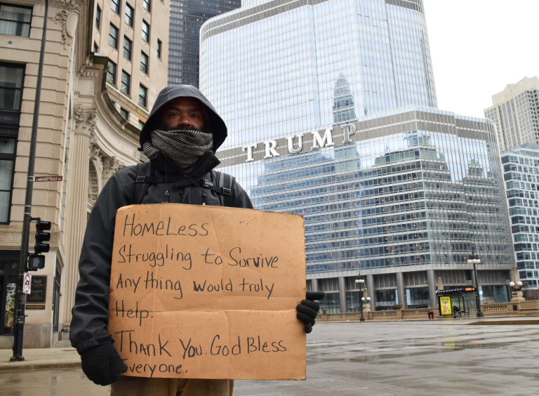 A homeless man stands in front of Trump Tower.