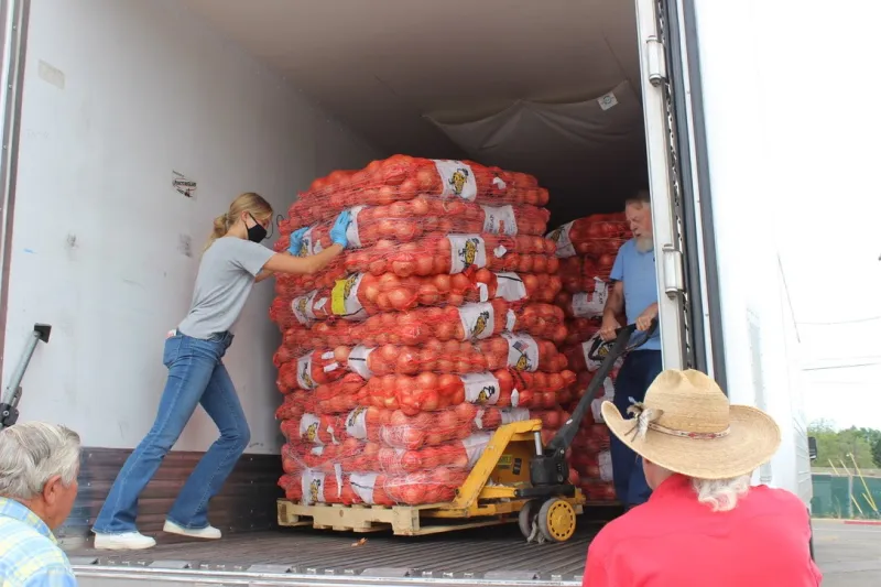 Stella Delp ’22 of FarmLink helps push one pallet of potatoes as part of the one millionth pound of food delivery to Siskyou. (Photo: courtesy of Stella Delp.)