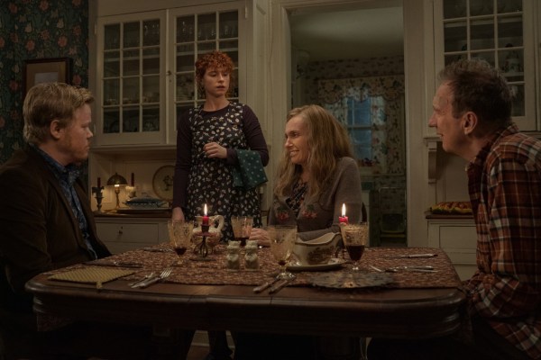 The cast of 'i'm thinking of ending things' sit at a dining room table.