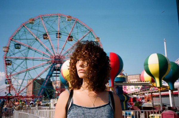 Loren Allred stands with a ferris wheel and carnival booths in the background.
