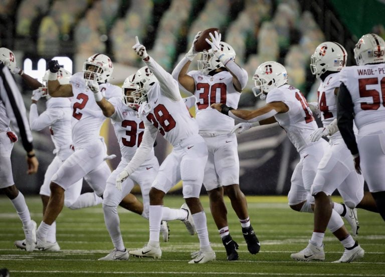 Sophomore inside linebacker Levani Damuni (30 above) celebrates an interception in the second quarter. He also picked up a fumble recovery. (Photo: ANDY NELSON/The Register-Guard)