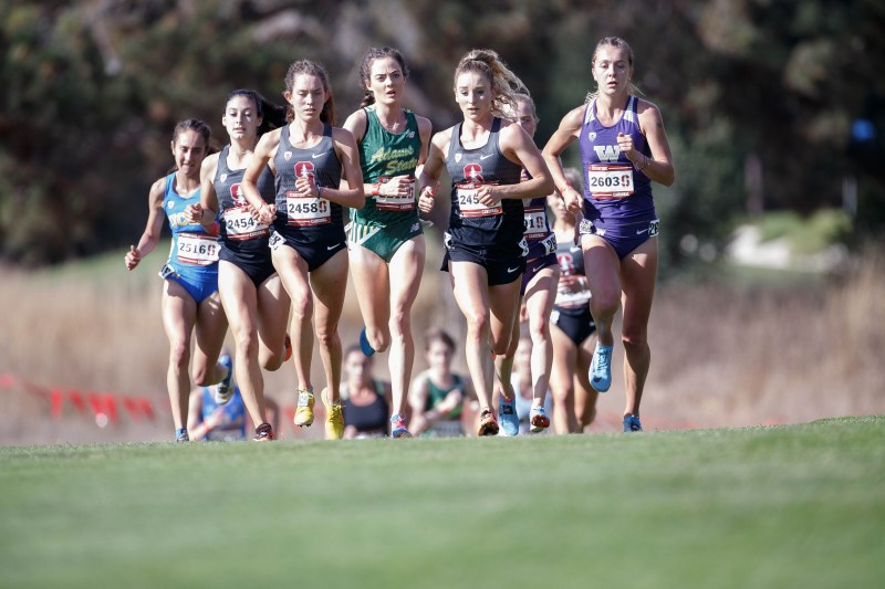 A group of female cross country runners running on the track