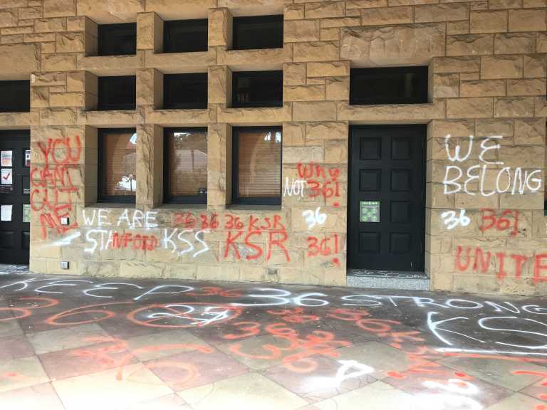 Slogans written in red and white washable chalk on Building 10