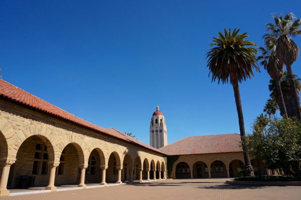 Stanford's main quad with Hoover tower visible in the background. The sky is bright blue.