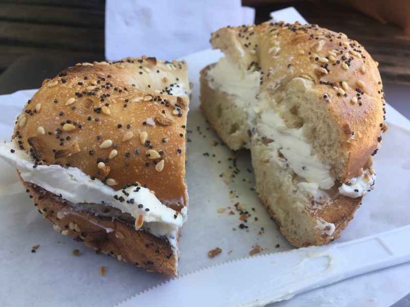 Close-up of an everything bagel with cream cheese, cut in half