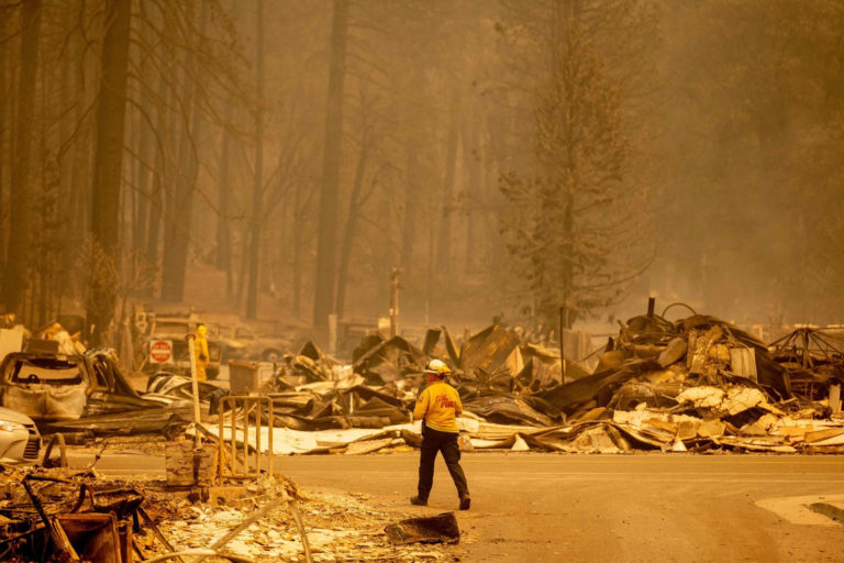 Firefighter in the middle of wreckage of Dixie Fie, surrounded in yellow haze