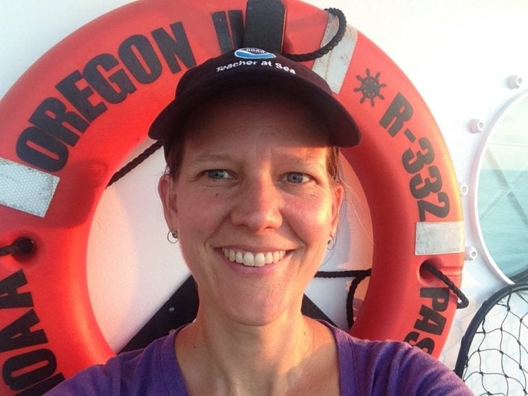A photo of Dr. Kate Schafer in front of a life buoy