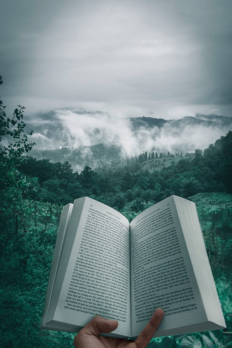 A decorative photo of an open book in the foreground and a waterfall in the background
