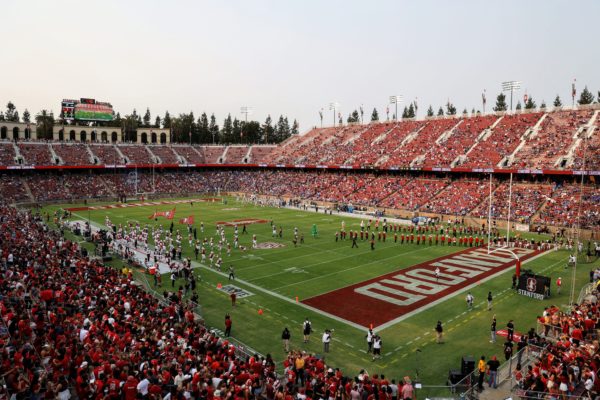 Football players run onto the field at Stanford Stadium before the team's game against UCLA.