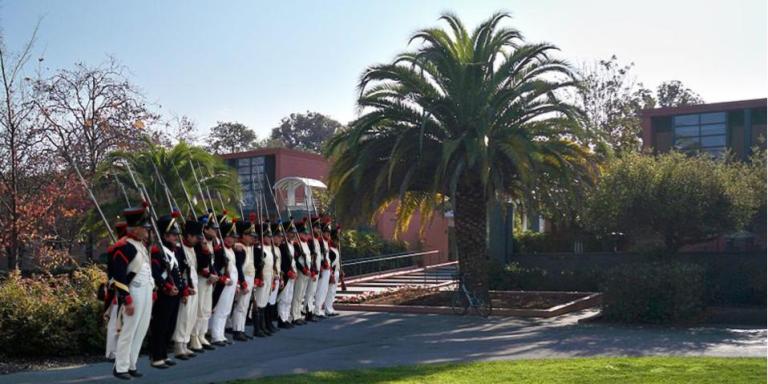 Soldiers wearing British colonial soldier outfits stand outside of Stern Hall.