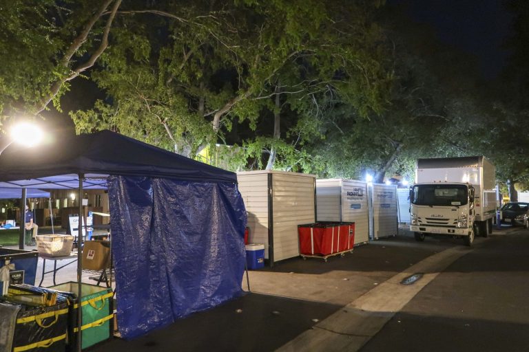 Tents and trucks holding packages outside of Kennedy Graduate Residences