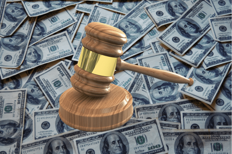 A gavel striking a pile of money