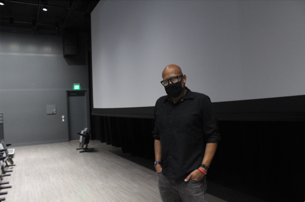 Filmmaker Kevin Jerome Everson stands in front of a projector