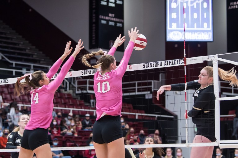 Junior opposite Kendall Kipp blocks a ball above the net.