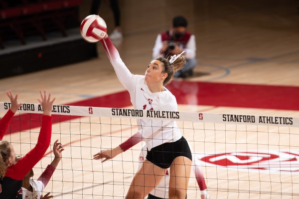 Redshirt sophomore middle blocker McKenna Vicini swings at a ball above the net.