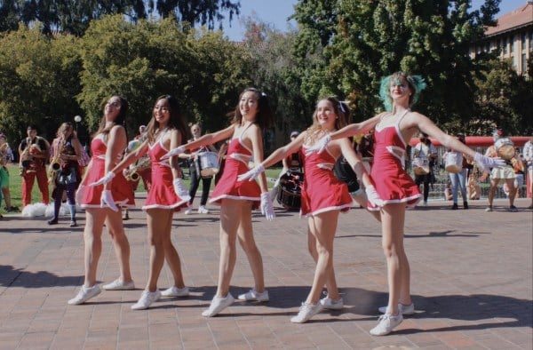 Five Stanford dollies pose outside Green library with their hands outstretchee