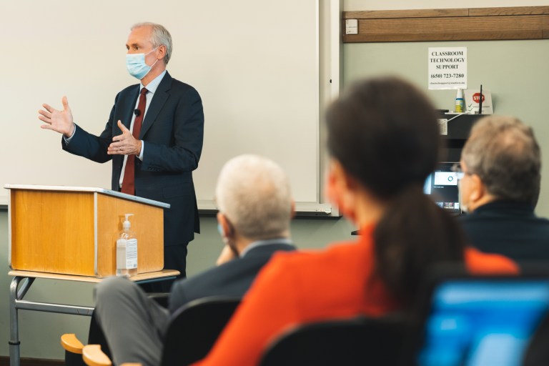 Marc Tessier-Lavigne in front of a podium speaking to the Faculty Senate