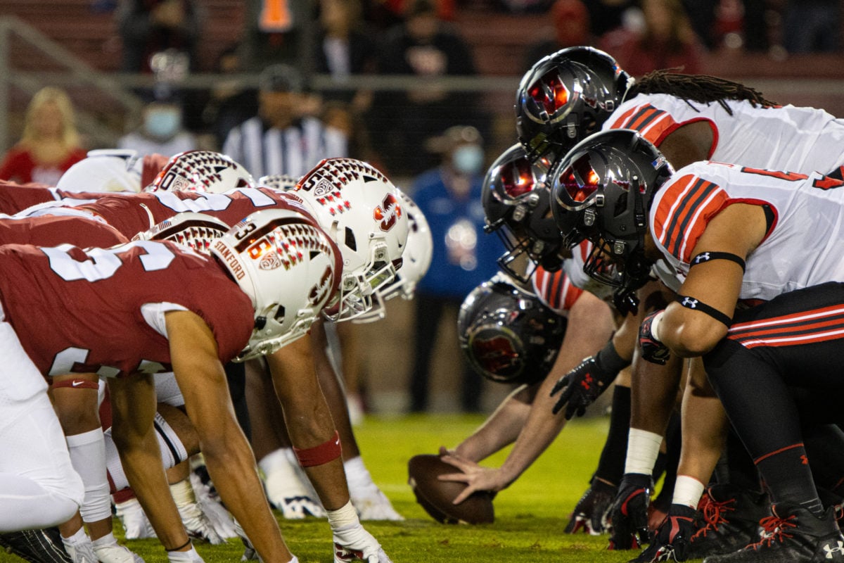 Utah's offensive line lines up against Cardinal defense, football in center. 
