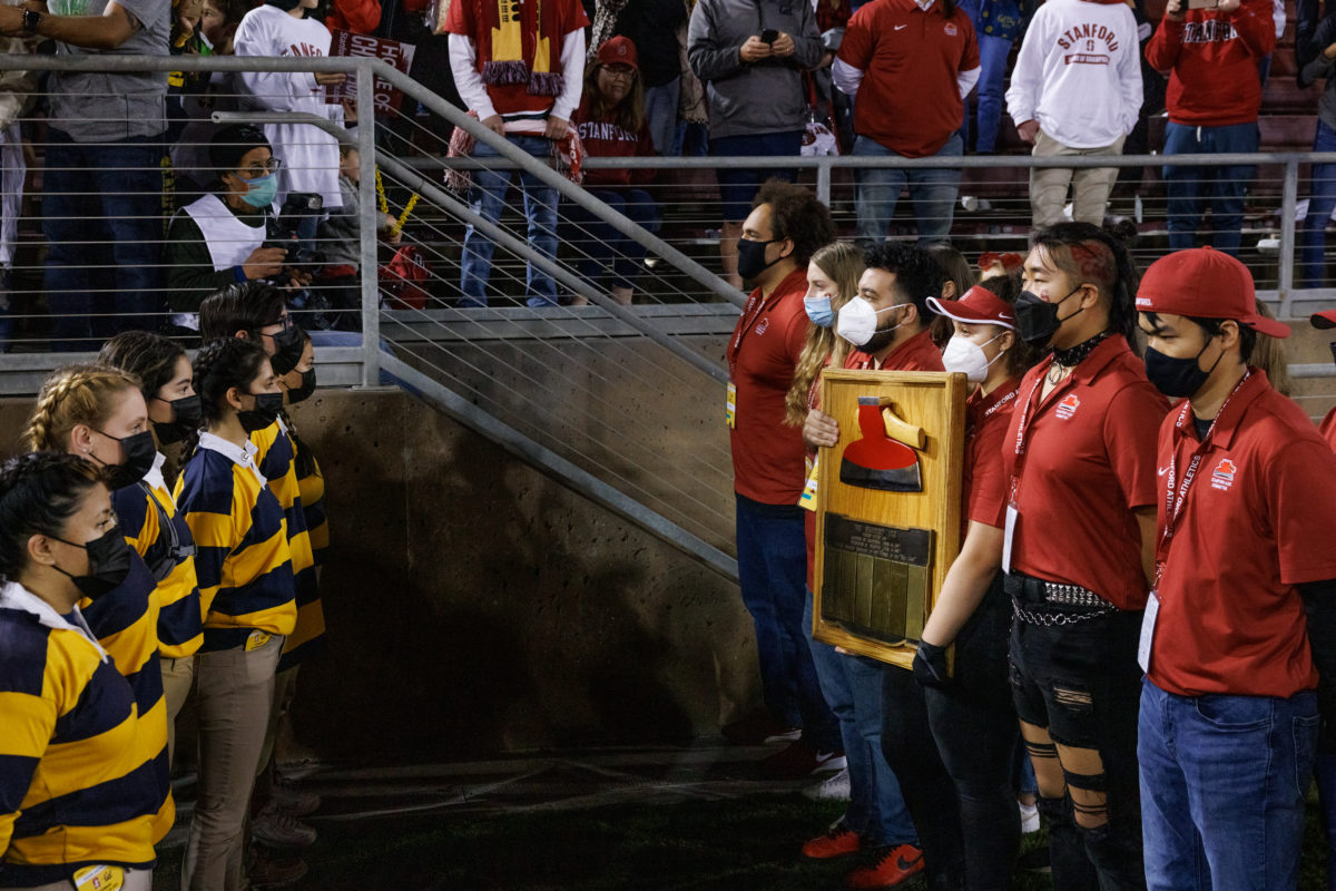 Cal's Axe Committee lined up on the left, staring down Stanford's Axe Committee holding the Axe on the right. 